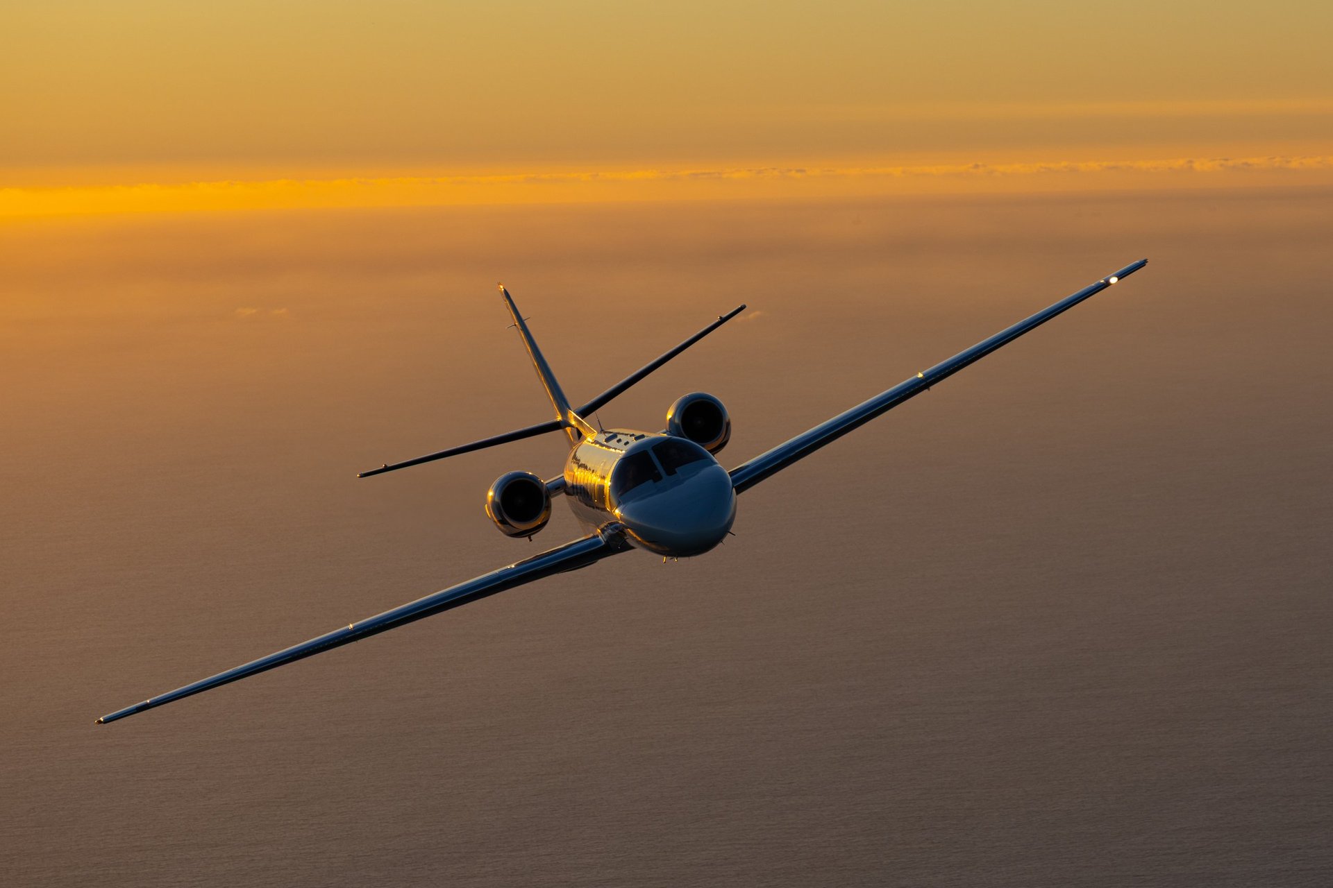 Business jet in sunset light over the Pacific Ocean